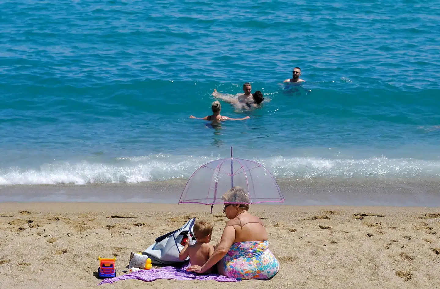 Et indtil coronapandemien utænkeligt billede fra Barcelonas bystrande på en højsommerdag i midten af juli. Normalt kan man ikke sparke sig frem for parasoller og liggestole, men i år har der været god plads til såvel de relativt få turister som lokale. Og sådan skulle det gerne blive ved med at være, mener beboerorganisationer.