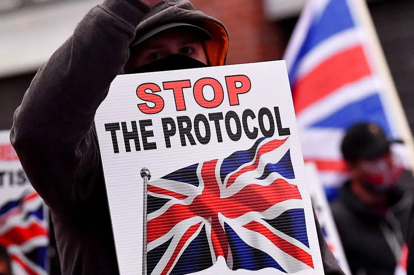 En demonstrant protesterer over den britiske aftale om Nordirland efter Brexit. »Lad være med at puste problemerne op, og lade være med at true med et totalt sammenbrud, hvis ikke I får jeres vilje,« skriver Kristian Mouritzen til briterne i denne leder.