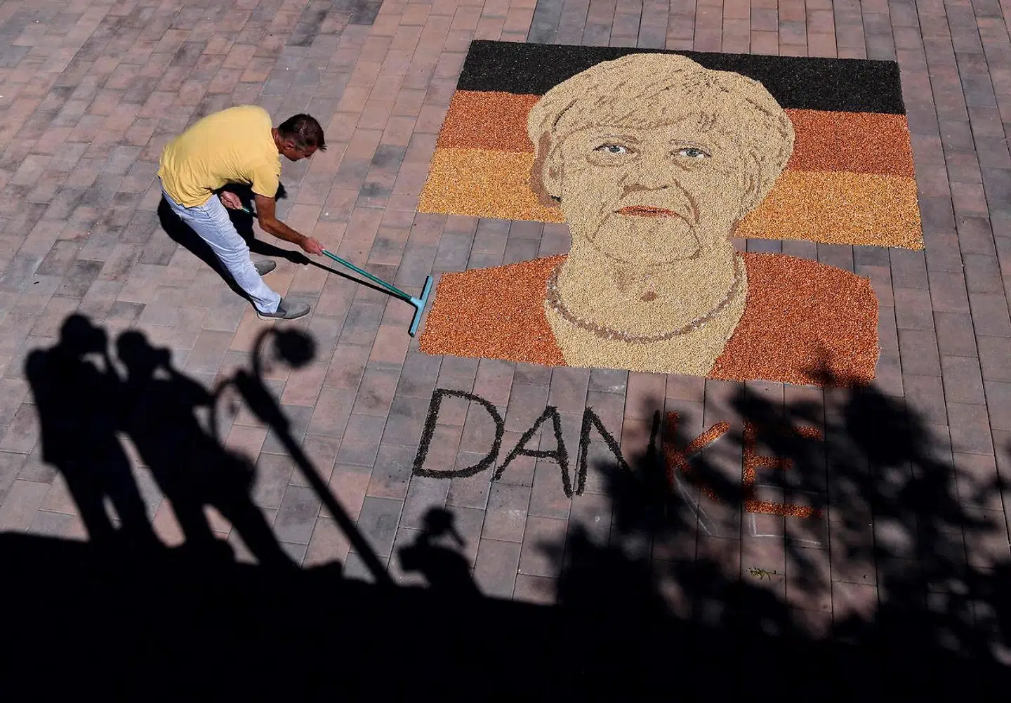 Kosovo-kunstneren Alkent Pozhegu arbejder på at skabe et portræt af den aftrædende bundeskansler Angela Merkel. Man kan vel tillade sig at kalde ingredienserne, der bruges, for ganske usædvanlige. Det skabes nemlig ved at placere korn og frø i en sindrig konstruktion.