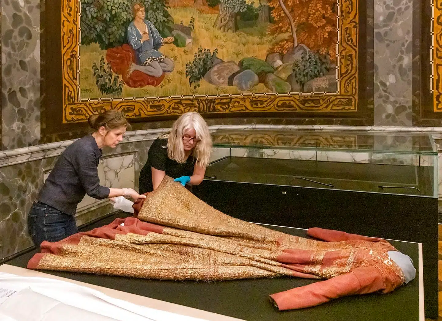 Dronning Margretes oprindelige kjole er mirakuløst bevaret. Den blev taget som krigsbytte af svenskerne, og er nu udlånt til Danmark og fremvises i udstillingen på Christiansborg om Margrete 1. På fotografiet ses museets ansatte brede den gamle kjole ud.