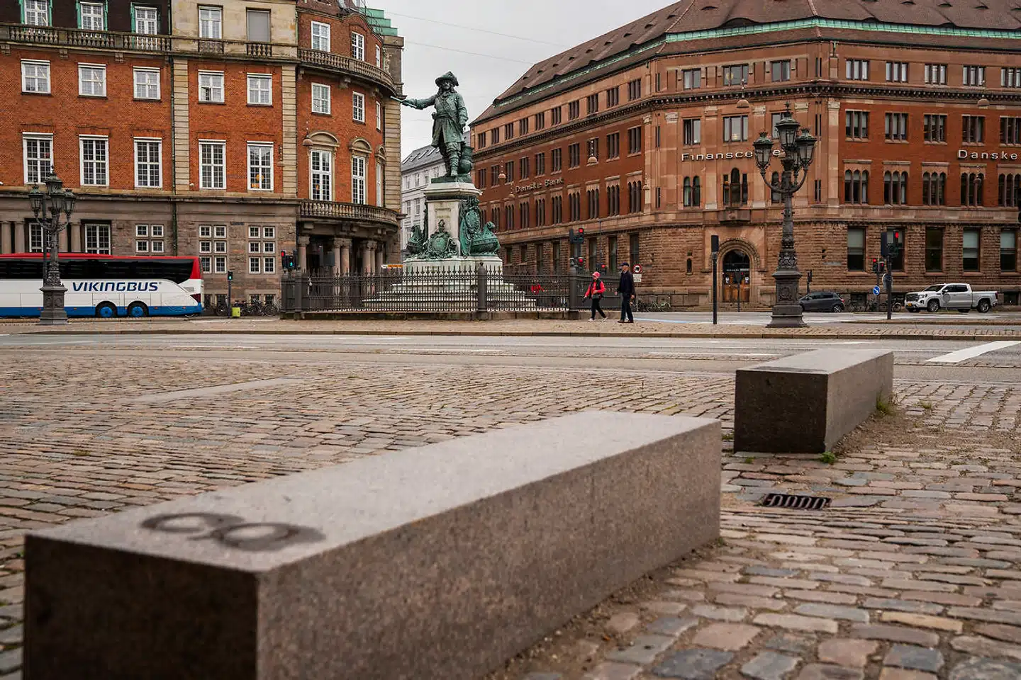 Over for statuen af Niels Juel ved Holmens Kanal er en serie bordursten nedfældet i brostenene, mens stenplinte fungerer som bænke.