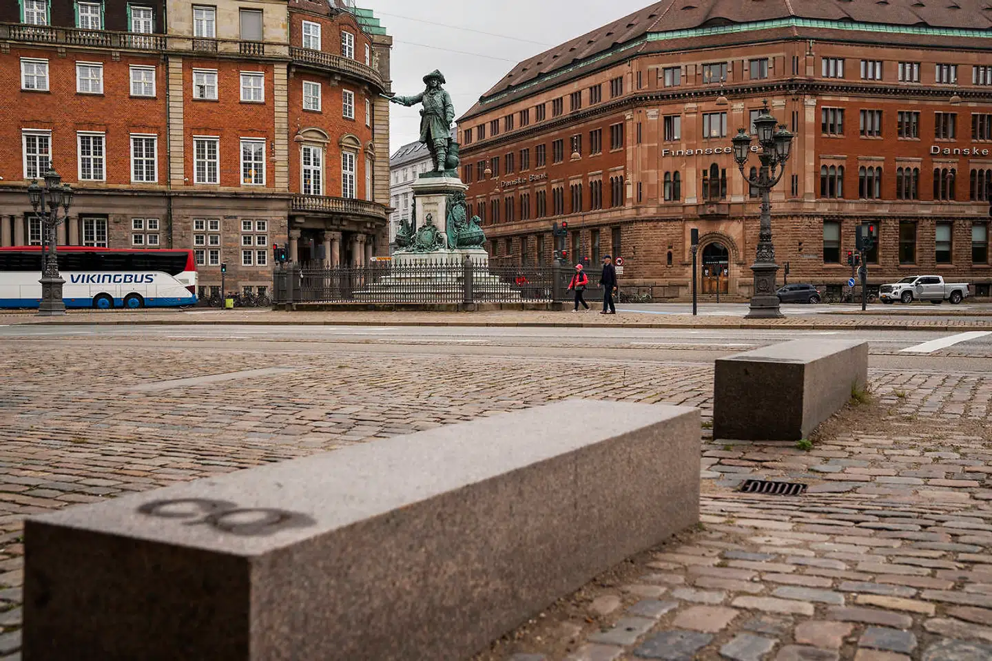 Over for statuen af Niels Juel ved Holmens Kanal er en serie bordursten nedfældet i brostenene, mens stenplinte fungerer som bænke.