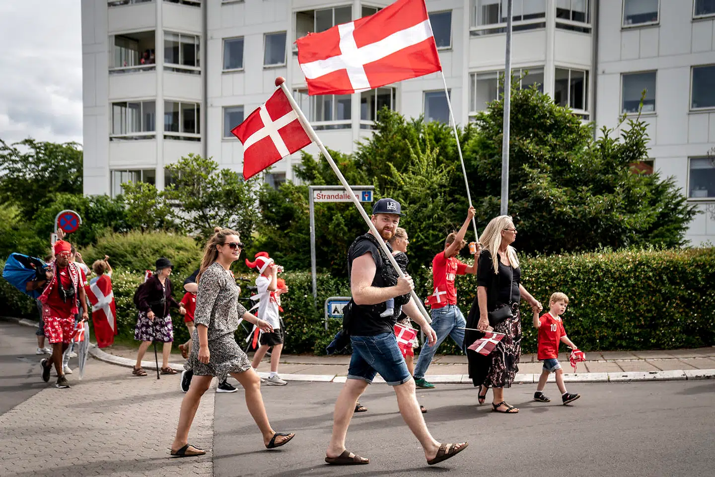 Fans i forbindelse med at det danske fodboldlandshold forlader Marienlyst Strandhotel i Helsingør, tirsdag den 6. juli 2021, forud for Danmarks semifinale mod England på Wembley stadion i London. Flaget samler satdig nationen, og det er der en særlig grund til, siger forsker. (Foto: Mads Claus Rasmussen/Ritzau Scanpix)