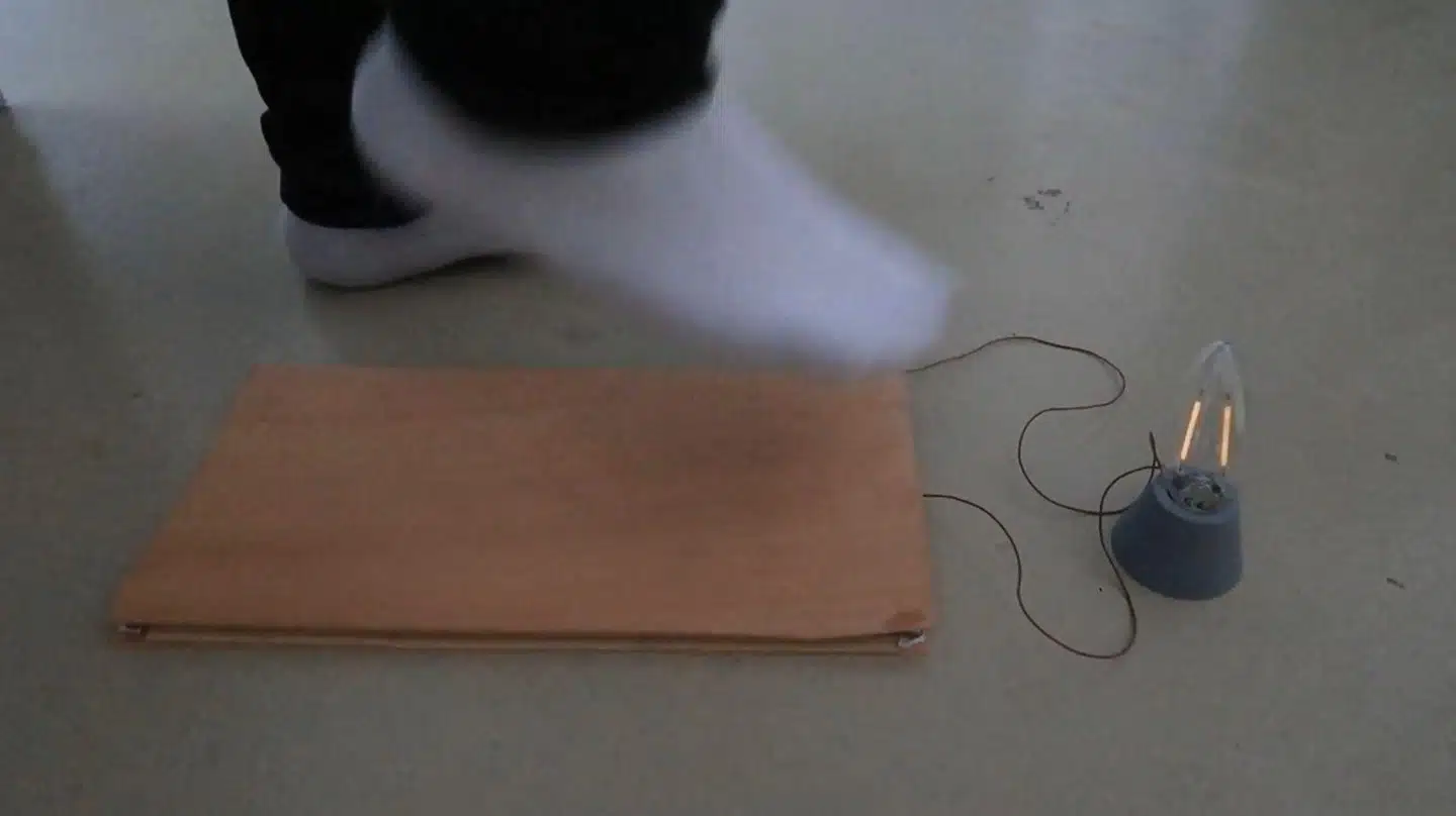 Ved at træde på og derefter løfte foden fra trægulvpladen frigives der energi, som kan bruges til strøm til pærer og mindre elektronik, viser schweiziske forskningsforsøg.