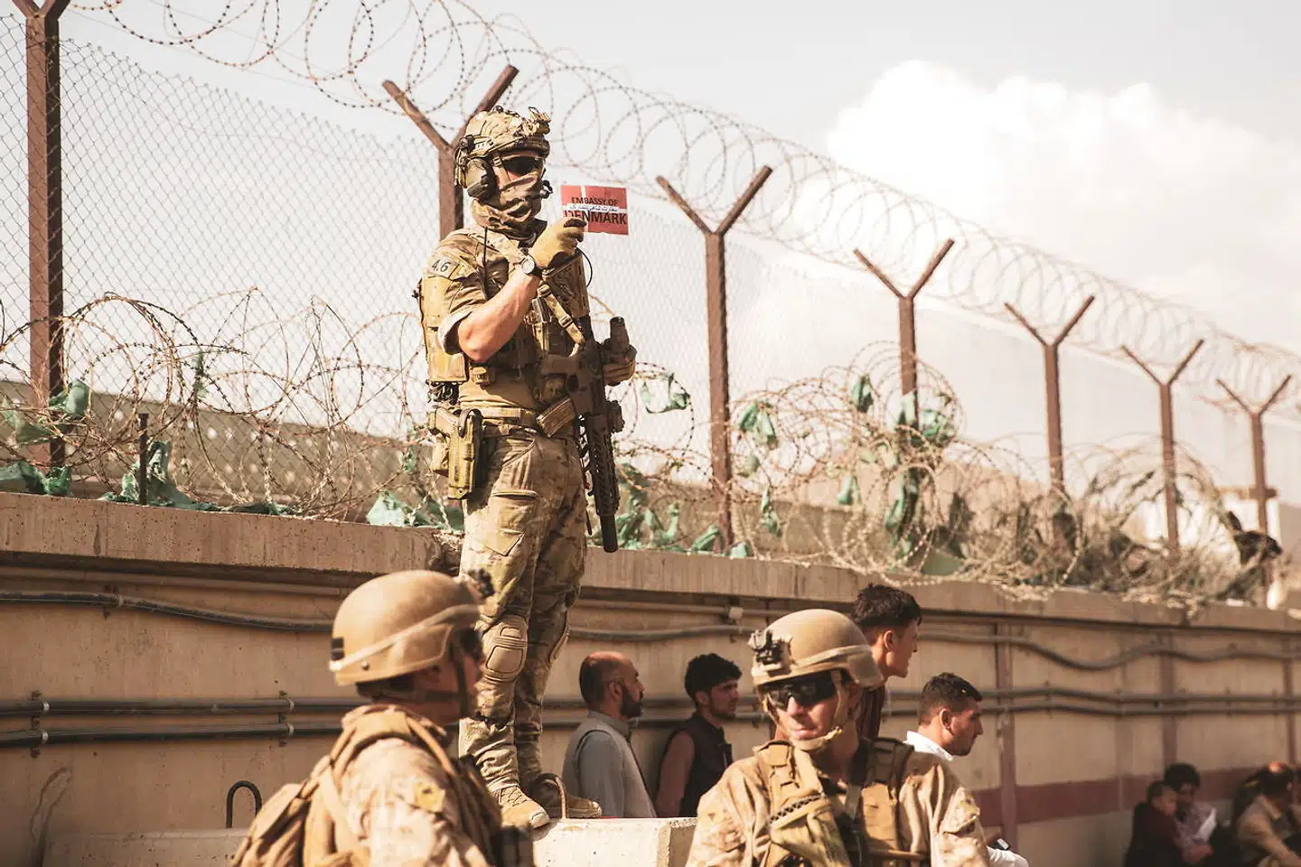 En dansk soldat holder det danske flag frem for at identificere familier under evakueringen fra Hamid Karzai International Airport i Kabul 21. august.