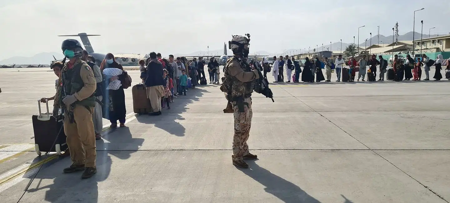 En gruppe af de heldige afghanere, som er sluppet ind i lufthavnsområdet, venter på at gå omborg på et italiensk fly