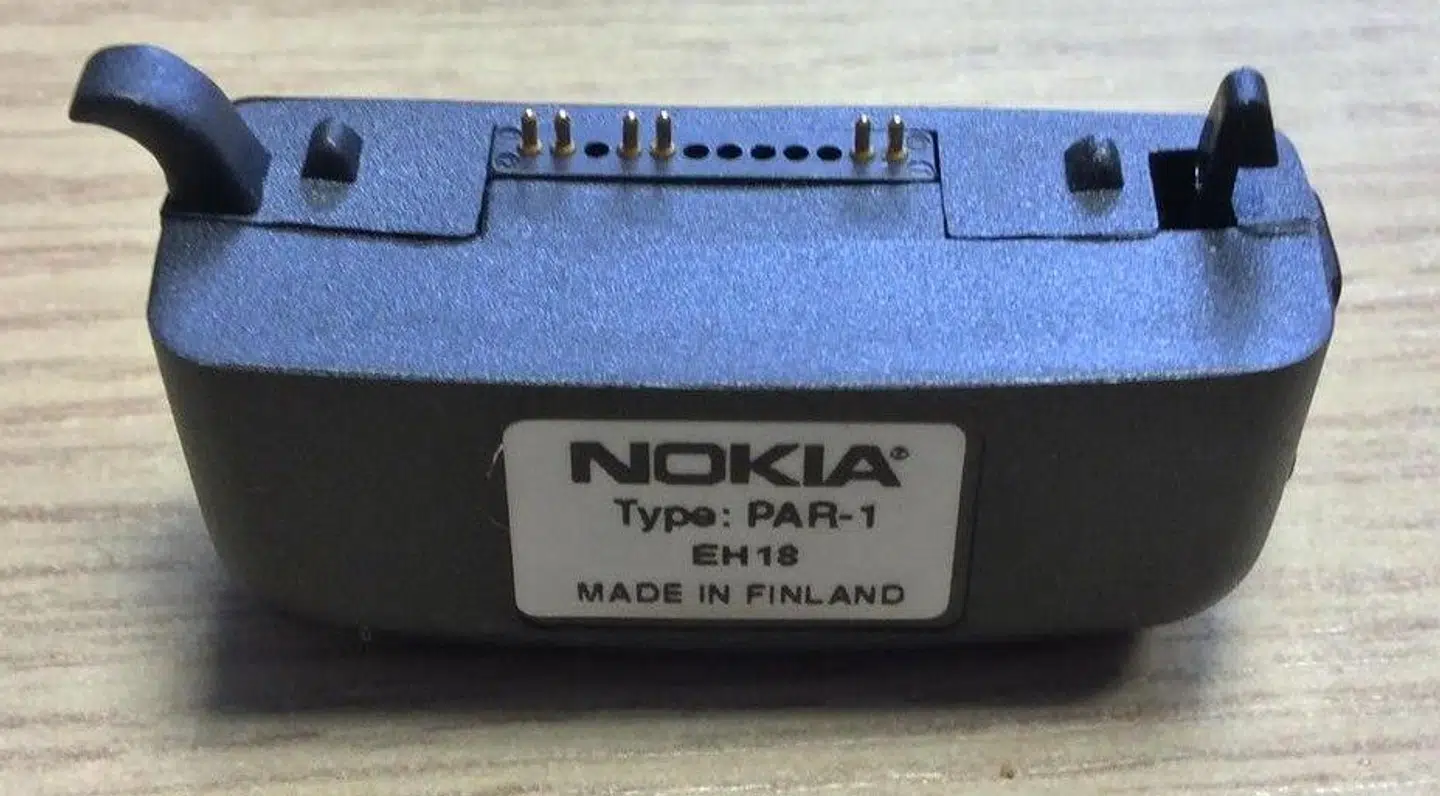 Denne flade plastikdims skulle sættes i enden af Nokia 9000 Communicator, før man kunne lade den op.