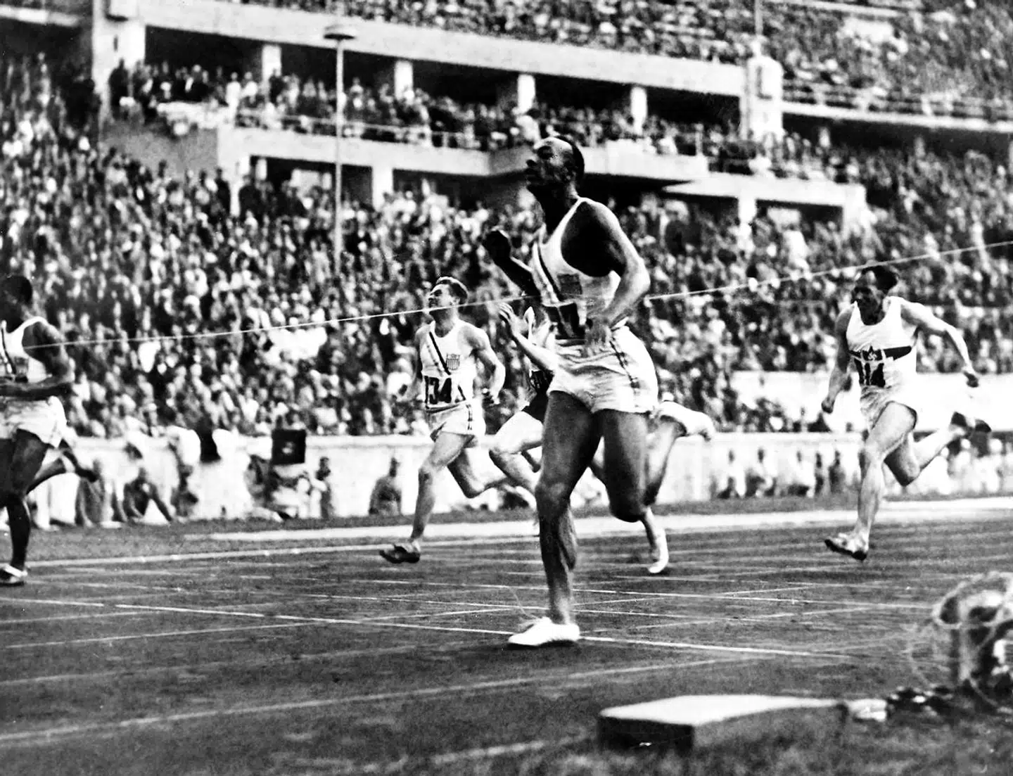 (FILES) In this file photo taken on August 5, 1936 US champion "Jesse" (James Cleveland) Owens crosses the finish line to win the 100m event, during Olympic Games in Berlin. - Owens exploded the Nazi-propagated myth of Aryan racial superiority when he won four athletics gold medals at the 1936 Berlin Olympics under the nose of Adolf Hitler. Grandson of a slave and legendary athlete, Jesse Owens established 6 world records in 1935. "Jesse" Owens retained his 100m world record for 20 years and his long jump world record for 25 years, until 1960. The 32nd Summer Olympics finally start on July 23 in Tokyo after a year's delay because of the coronavirus pandemic. (Photo by - / AFP)