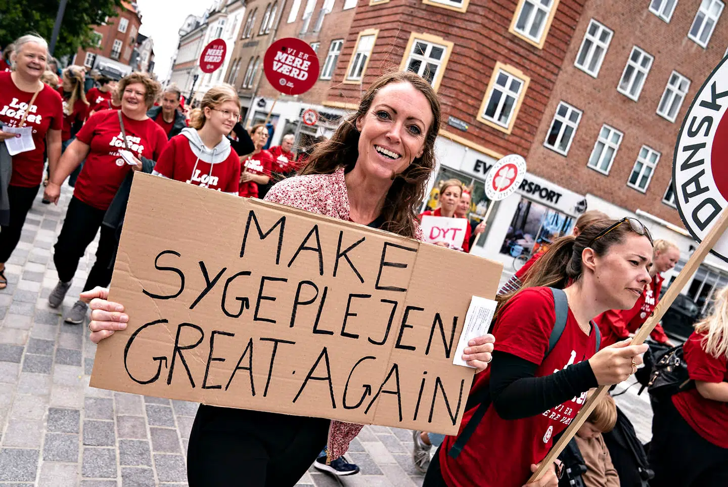 En sygeplejerske med skiltet: Make Sygeplejen great again da sygeplejersker i strejke demonstrerer i Aalborgs midtby, fredag den 30. juli 2021. Strejken for mere i løn begyndte 19. juni og optrappes i august.