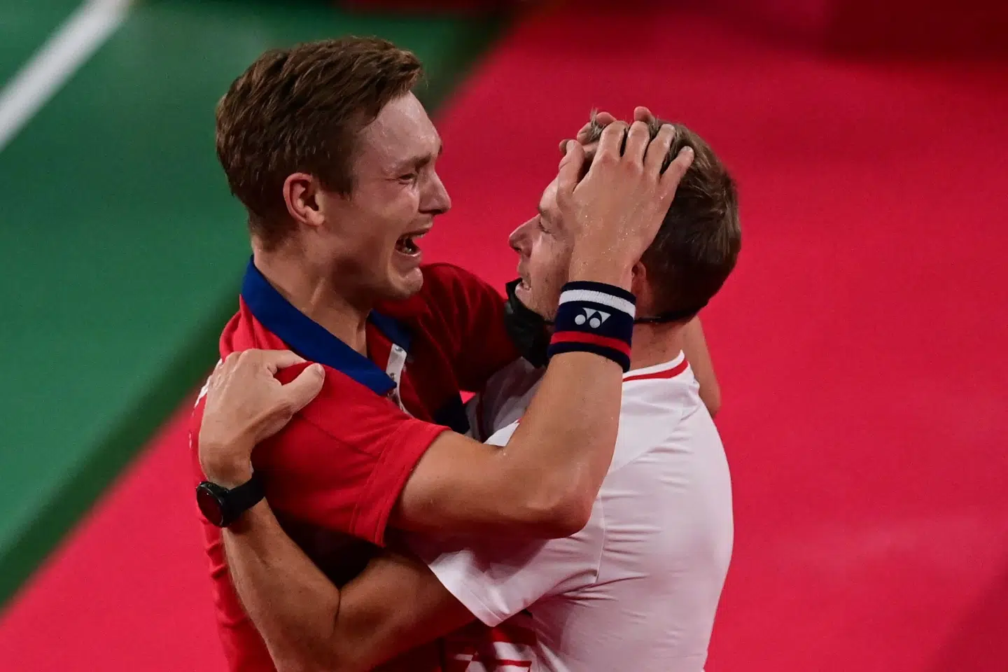 Axelsen falder i armene på træner Kenneth Jonassen efter kampen. Pedro Pardo/Ritzau Scanpix