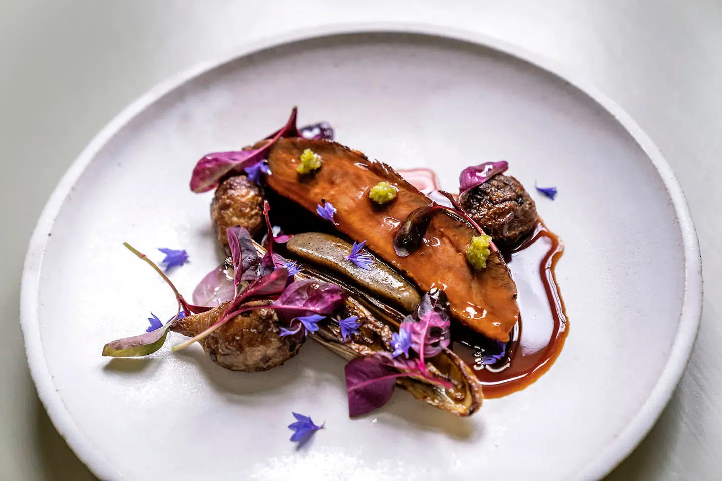 Canette med seje jordskokker, hengemte ribs og sauce på røde bær på Fasangården.