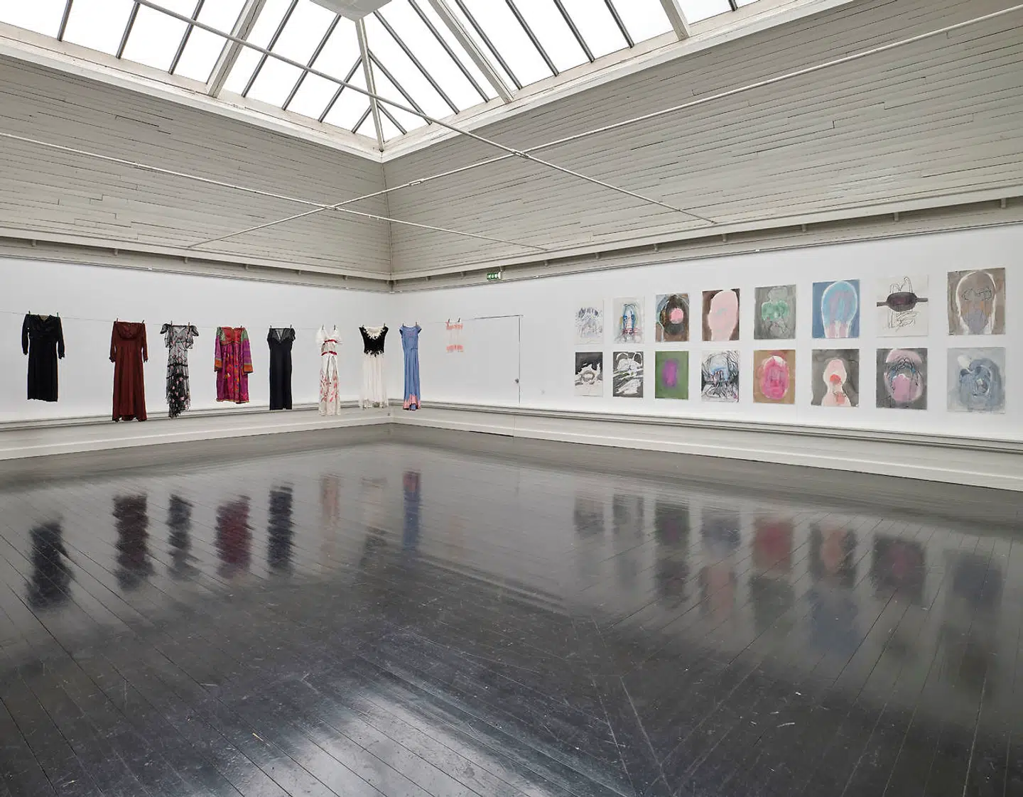 »My clothes are my diffent identities« hedder Ursula Reuter Christiansens installation, der flankeres af en stringent serie af udtonede akvarelansigter af Janaina Tschäpe, »Self Portrait«.