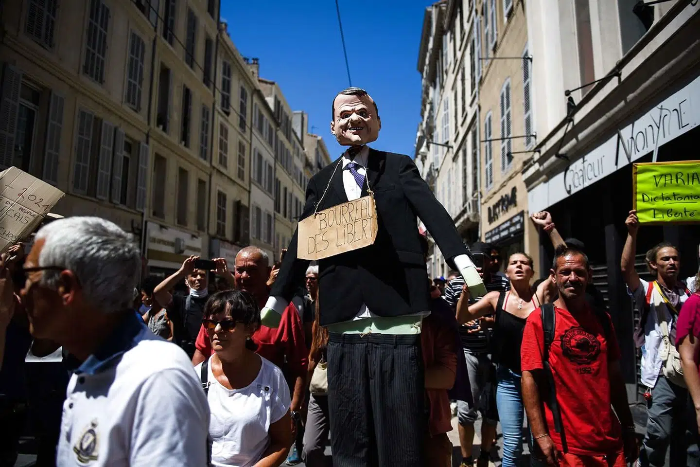 Demonstranter i Marseille i Sydfrankrig bærer en dukke, som forestiller præsident Emmanuel Macron, gennem byen med et skilt om halsen, hvorpå der står »frihedens slagter«.