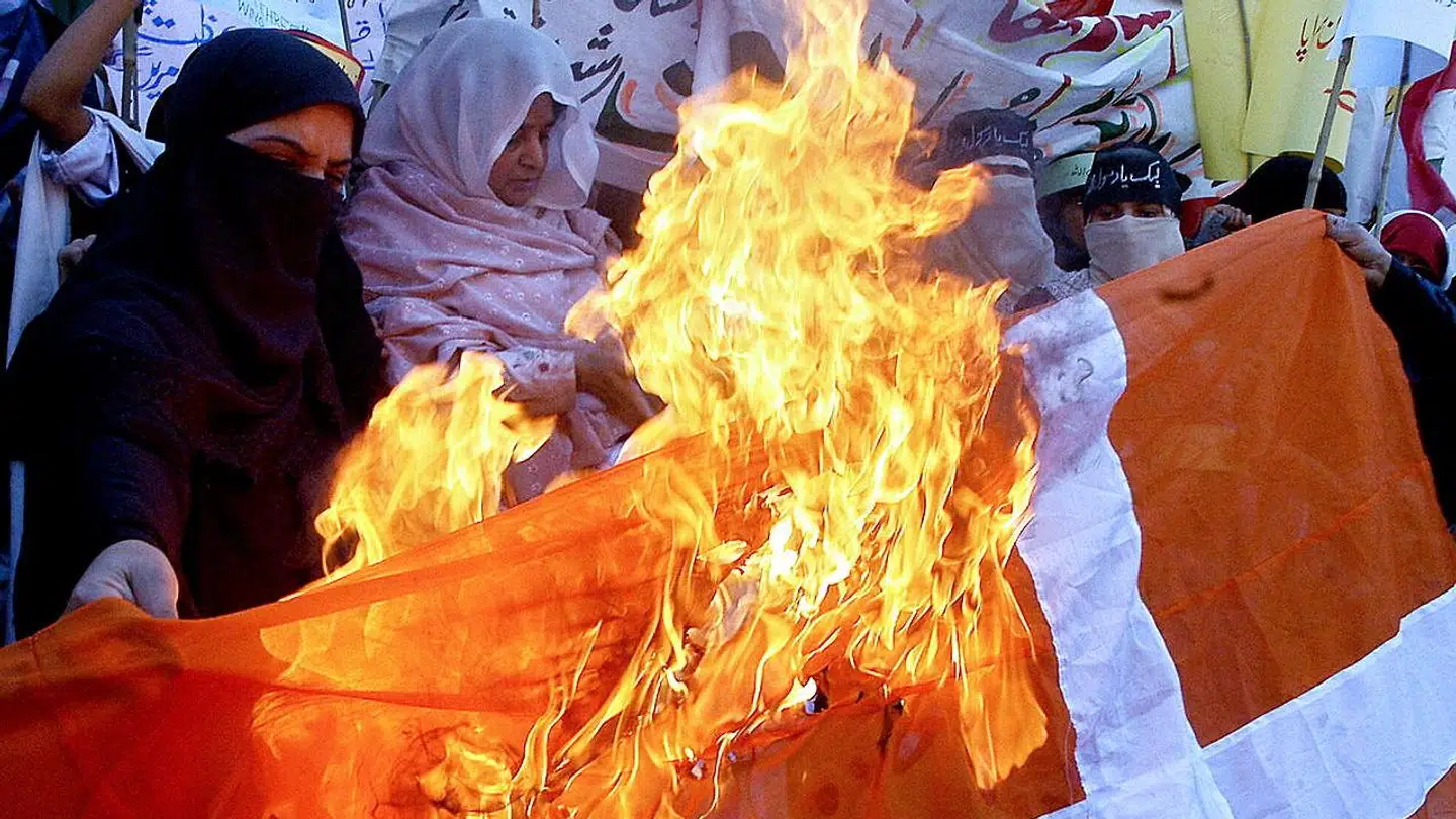 Pakistanske muslimer i færd med at brænde Danneborg af i Lahore i Pakistan under Muhammed-krisen i 2006.