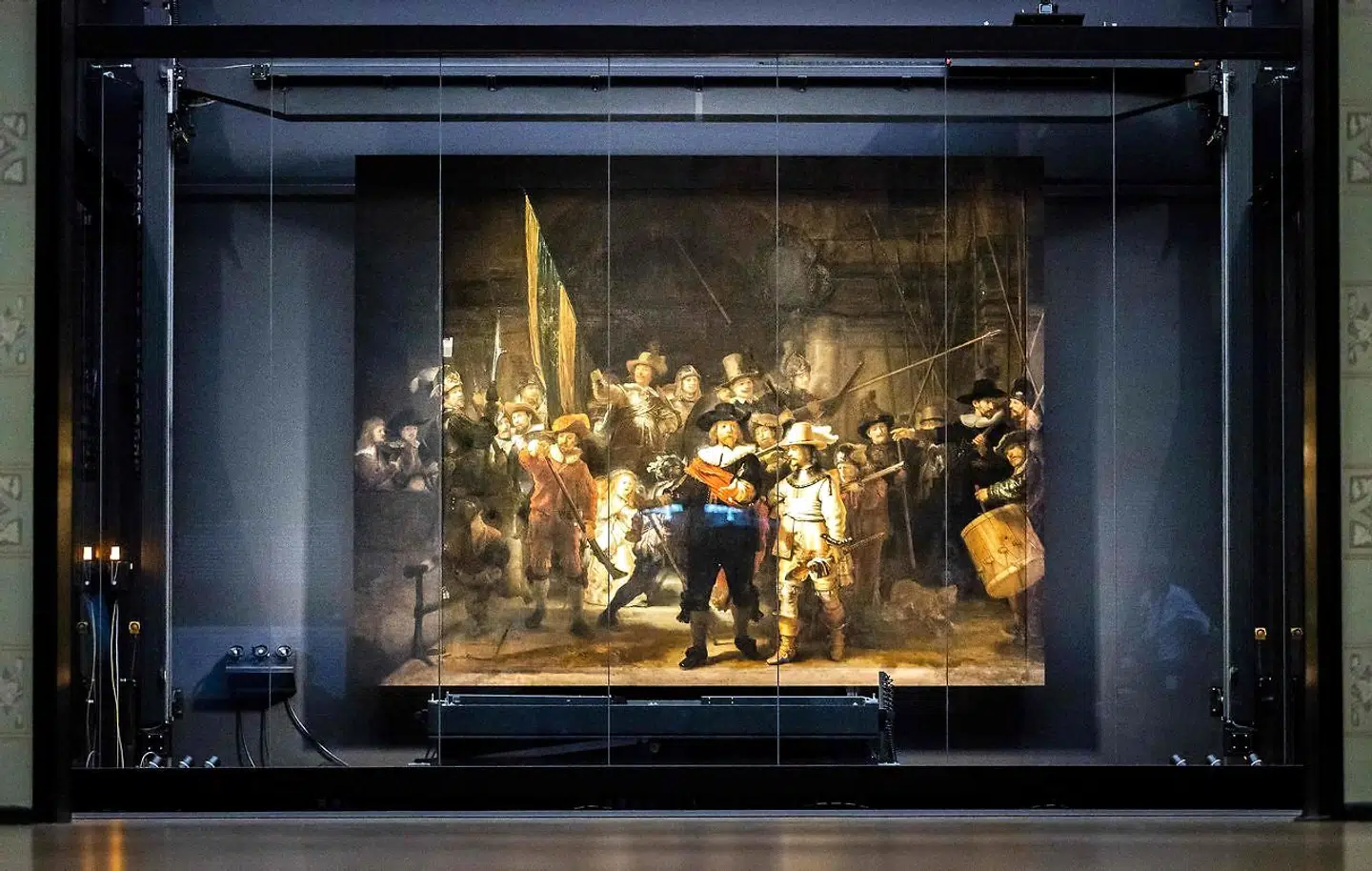 Den rekonstruerede udgave af Rembrandts »Nattevagten« fra 1642 kan i de kommende måneder ses på Rijksmuseum i Amsterdam. De rekonstruerede dele af maleriet kan ses i begge sider af billedet, som et tåget bånd fra bund til top.