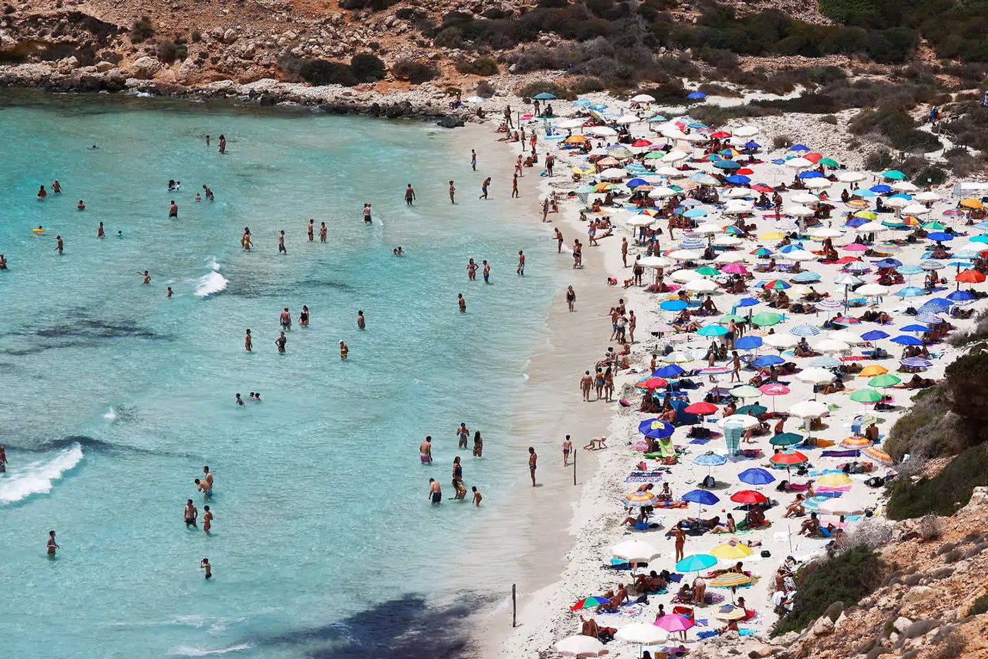 Turister på stranden, Lampedusa, Italien. 21 lande er fra lørdag grønne i rejsevejledningerne, herunder også Italien.