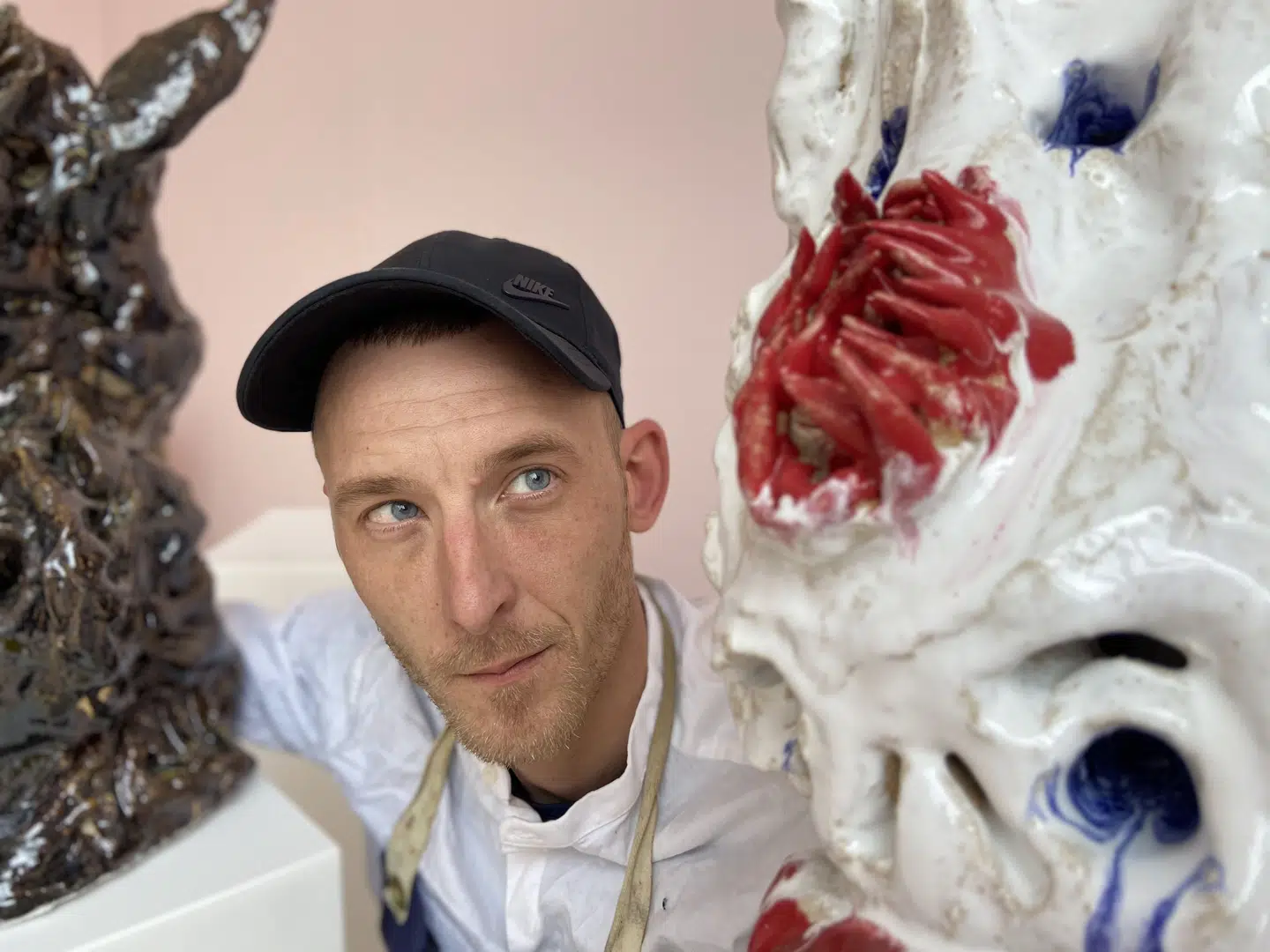 Næblerød poserer sammen med to lerfigurer.