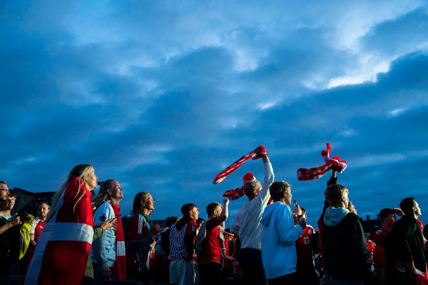 Fans følger med i Danmarks kamp mod Rusland, der blev vist på storskærm på Ofelia Beach i København mandag aften. »Vi ved også, at nationalismen findes i en ondartet form, og derfor er det værd at hylde de smukke værdier, som det danske landshold har gjort levende,« skriver Pierre Collignon i denne leder.