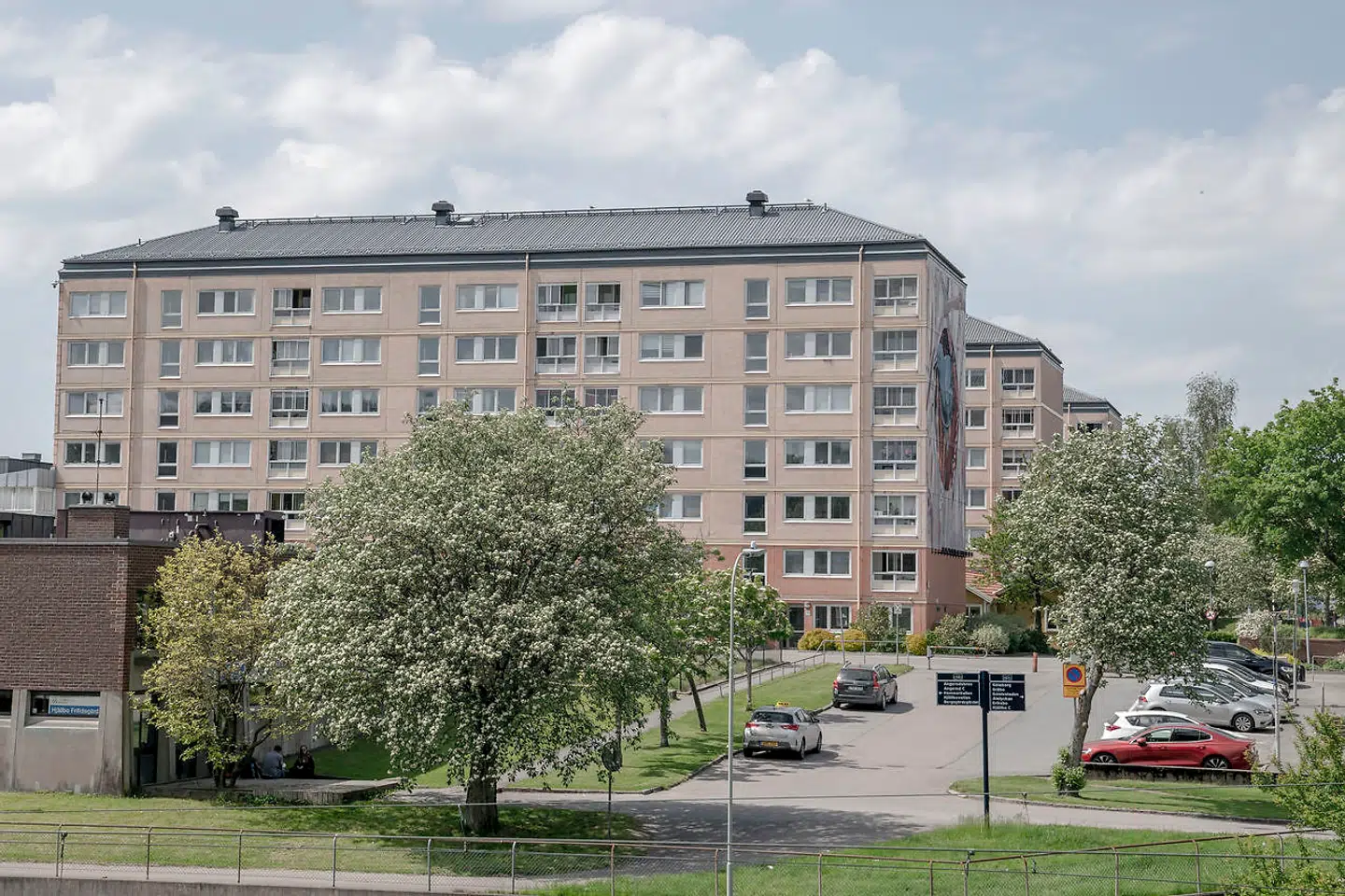 Boligblokke beliggende ud til den centrale plads i Göteborg-forstaden Hjällbo, hvor en mand blev skuddræbt den sidste søndag i maj. Forstaden ligger få kilometer nord for det centrale Göteborg. Beboere fortæller, at det er normalt at møde narkohandel i området, som siges at være kontrolleret af en kriminel familie, der bor i området.