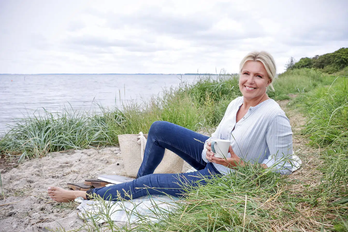 Merkur Andelskasses direktør, Charlotte Skovgaard, hygger sig på stranden efter at have indført ligeløn blandt cheferne i den alternative bank. Foto: Jan Lennart Pedersen