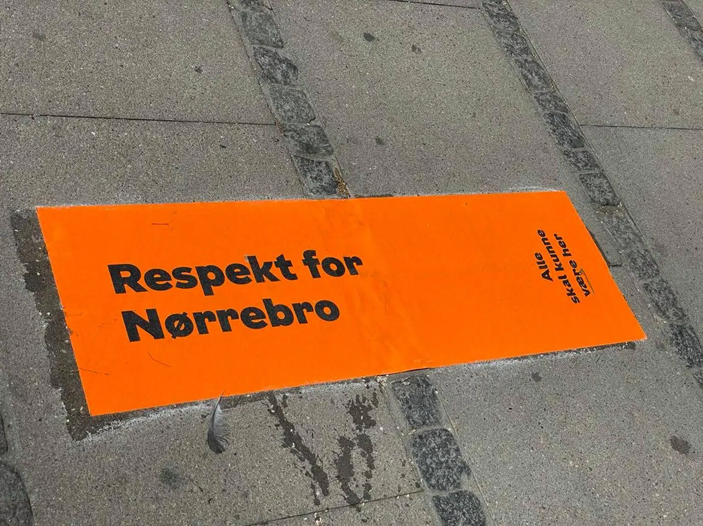 »Respekt for Nørrebro« står der på fliserne på Dronning Louises Bro mellem Indre By og Nørrebro, som en venlig reminder til de festglade folk.