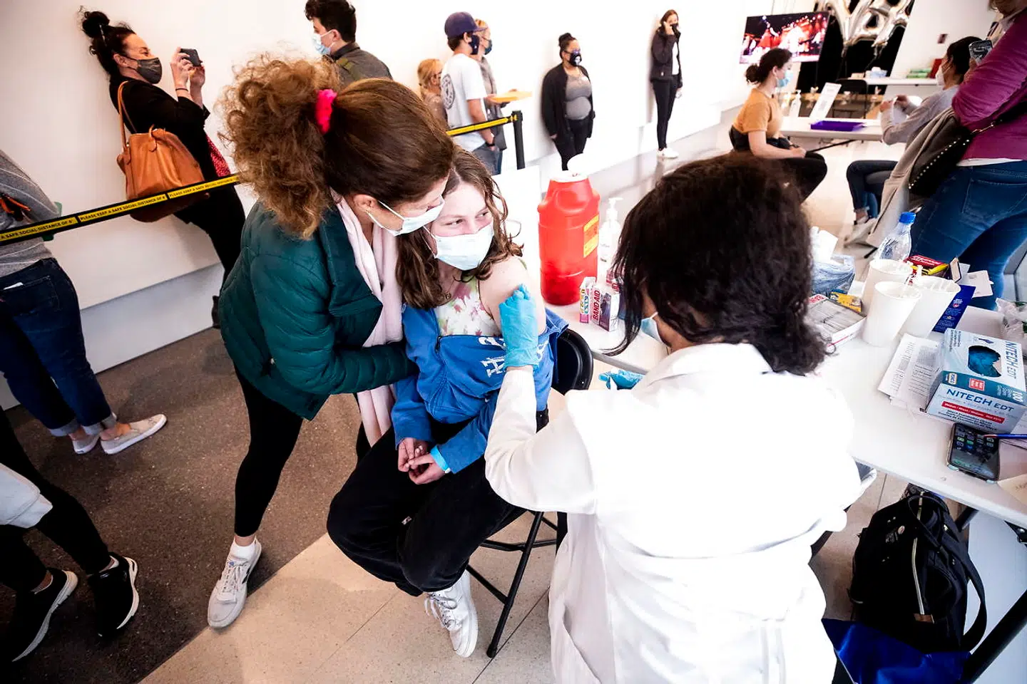 epa09198577 A 14-year-old girl is hugged by her mother after receiving a dose of COVID-19 vaccine during a vaccination drive organized by the Annenberg Foundation and Mickey Fine Pharmacy for teenagers aged between 12 and 15 at the Annenberg Foundation in Los Angeles, California, USA, 13 may 2021. The Pfizer vaccine was cleared on 13 May to be inoculated in people of 12 years of age and older. EPA/ETIENNE LAURENT