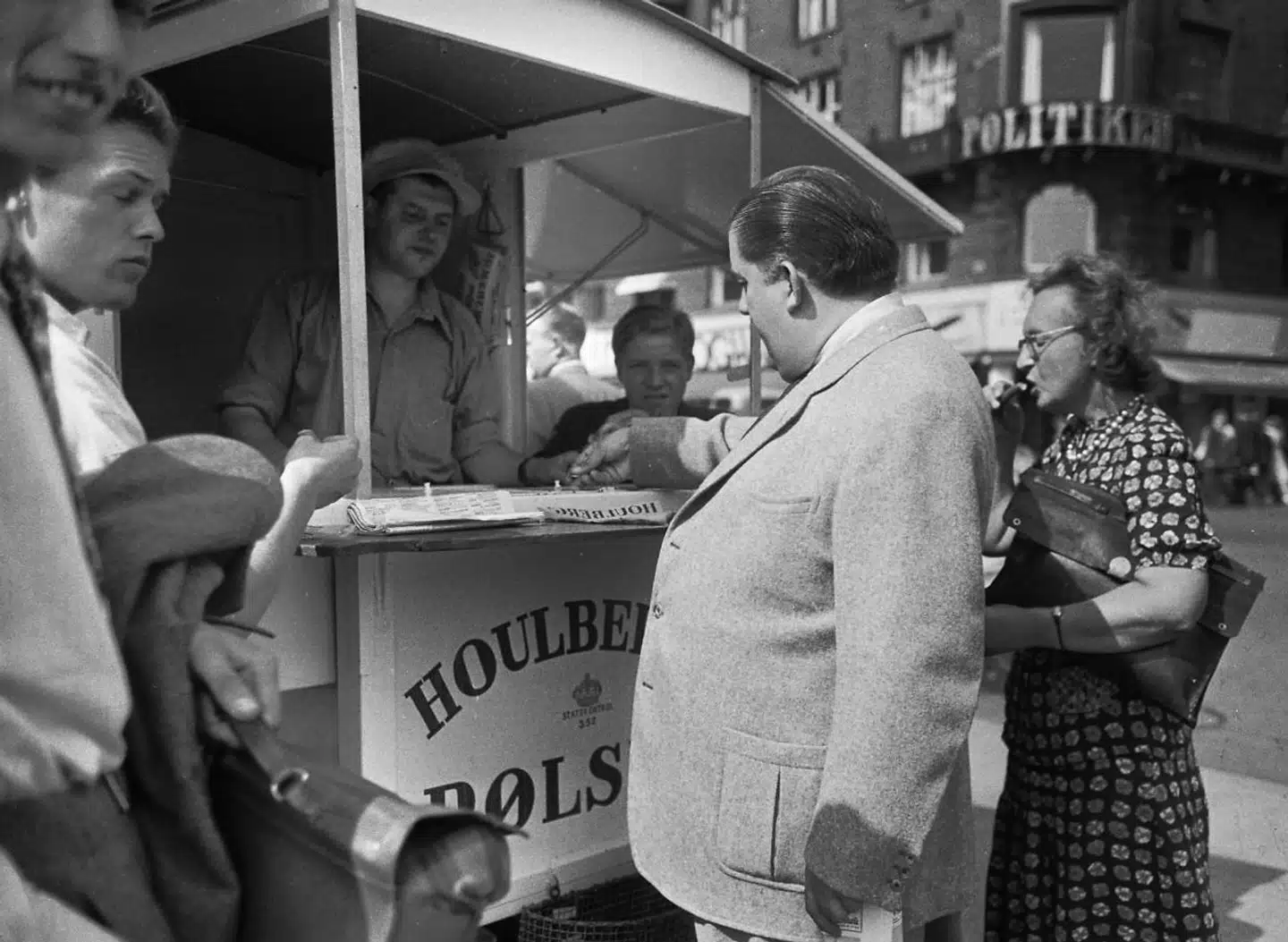 Pølsevognen har rundet 100 år, og i den forbindelse har Danish Crown indledt en kampagne for at bevare kulturen – blandt andet med en mindeplade på Rådhuspladsen. Det er dog ikke alle, som mener, det er en god idé. På fotoet ses skuespilleren Ib Schønberg i færd med at betale for sit måltid.