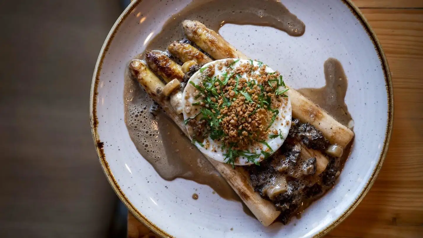 Stodderagtig servering af asparges med spejlæg, morkelsauce og kyllingeskind.