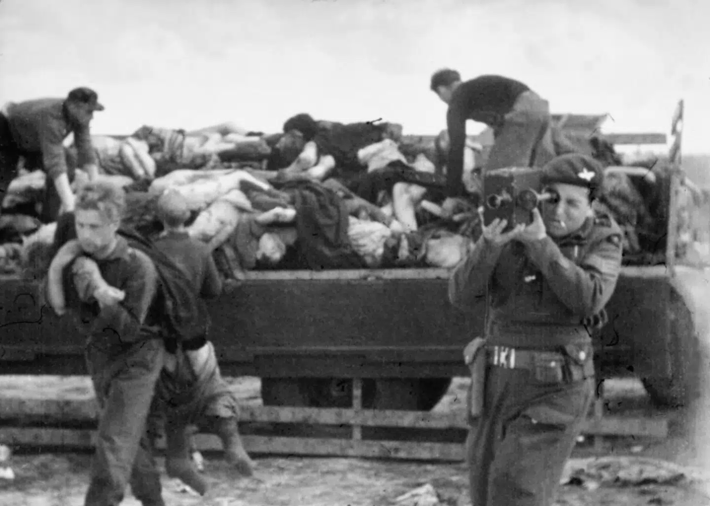 Mike Lewis var engelsk-jødisk fotograf, der var en af de første, der fotograferede rædslerne i kz-lejrene. Her er han i gang med at fotografere lig på en lastbil i Bergen-Belsen. Lewis kom også til møn og fotograferede de tidligere fanger fra Stutthof. Illustration fra bogen.