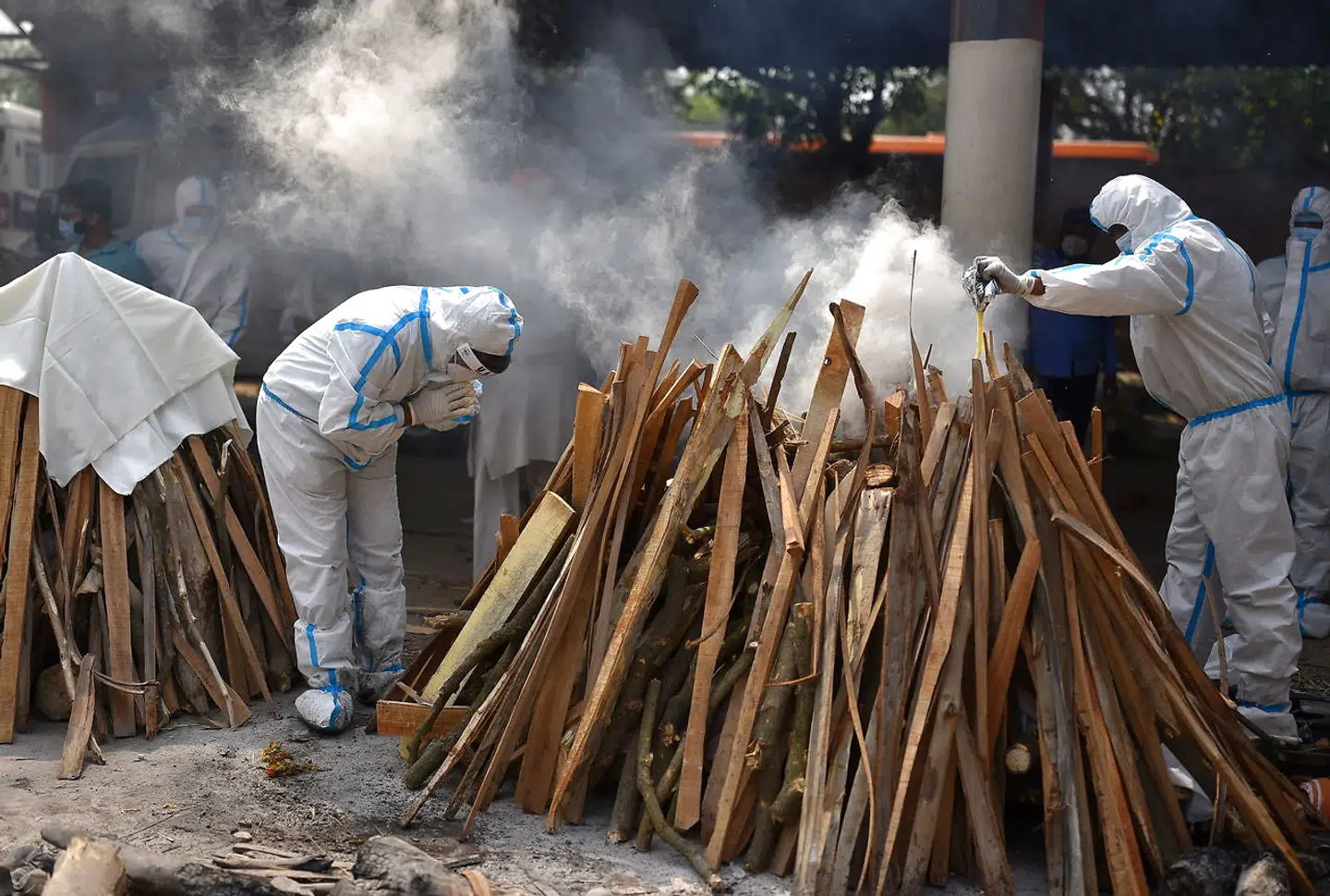 Familiemedlemmer iført sikkerhedsdragter må selv udføre begravelsesritualer for de afdøde.