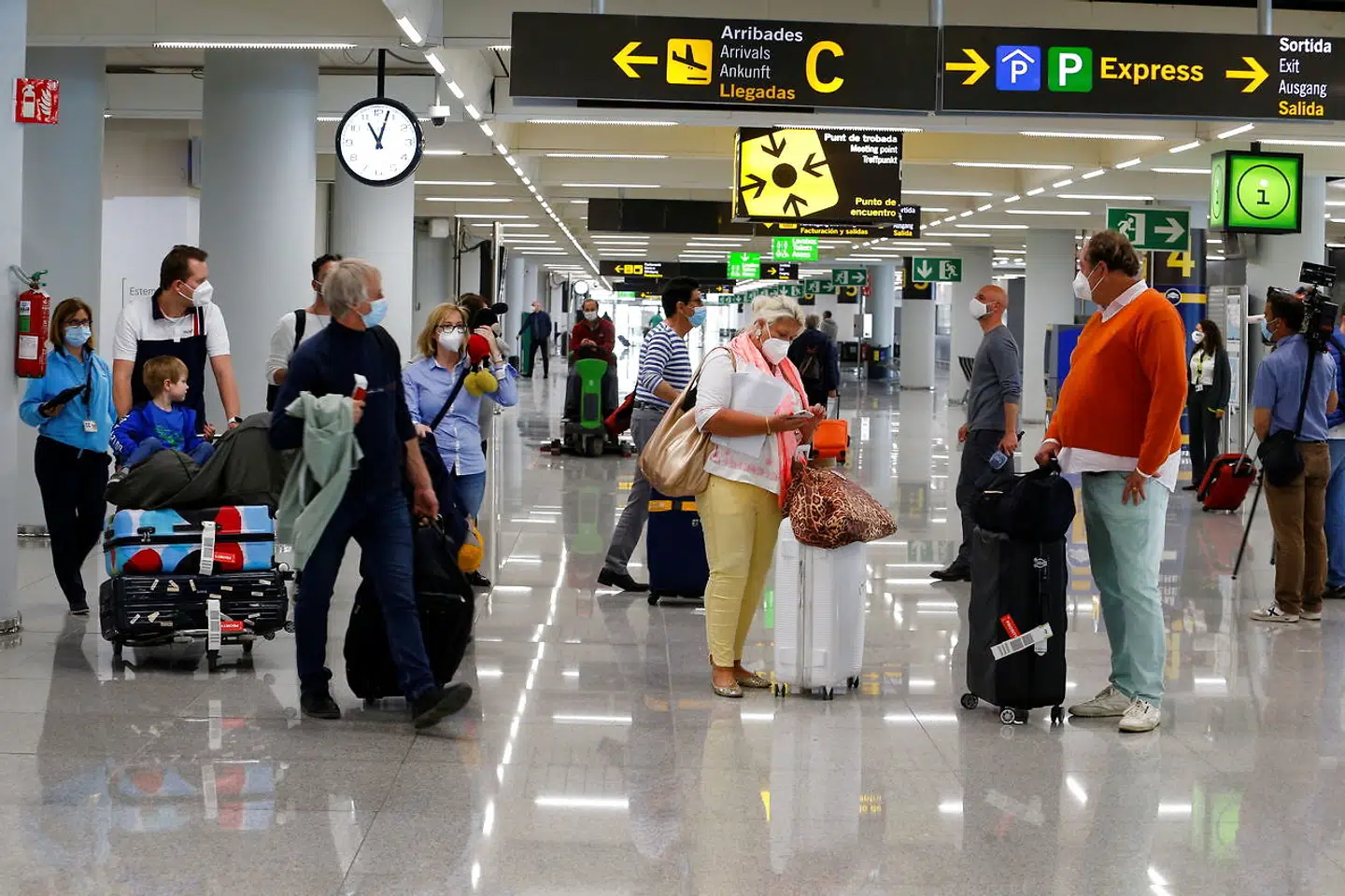 Turister iført ansigtsmasker ankommer til Son Sant Joan-lufthavnen i Palma de Mallorca 1. april 2021 for at feje påske på øen.