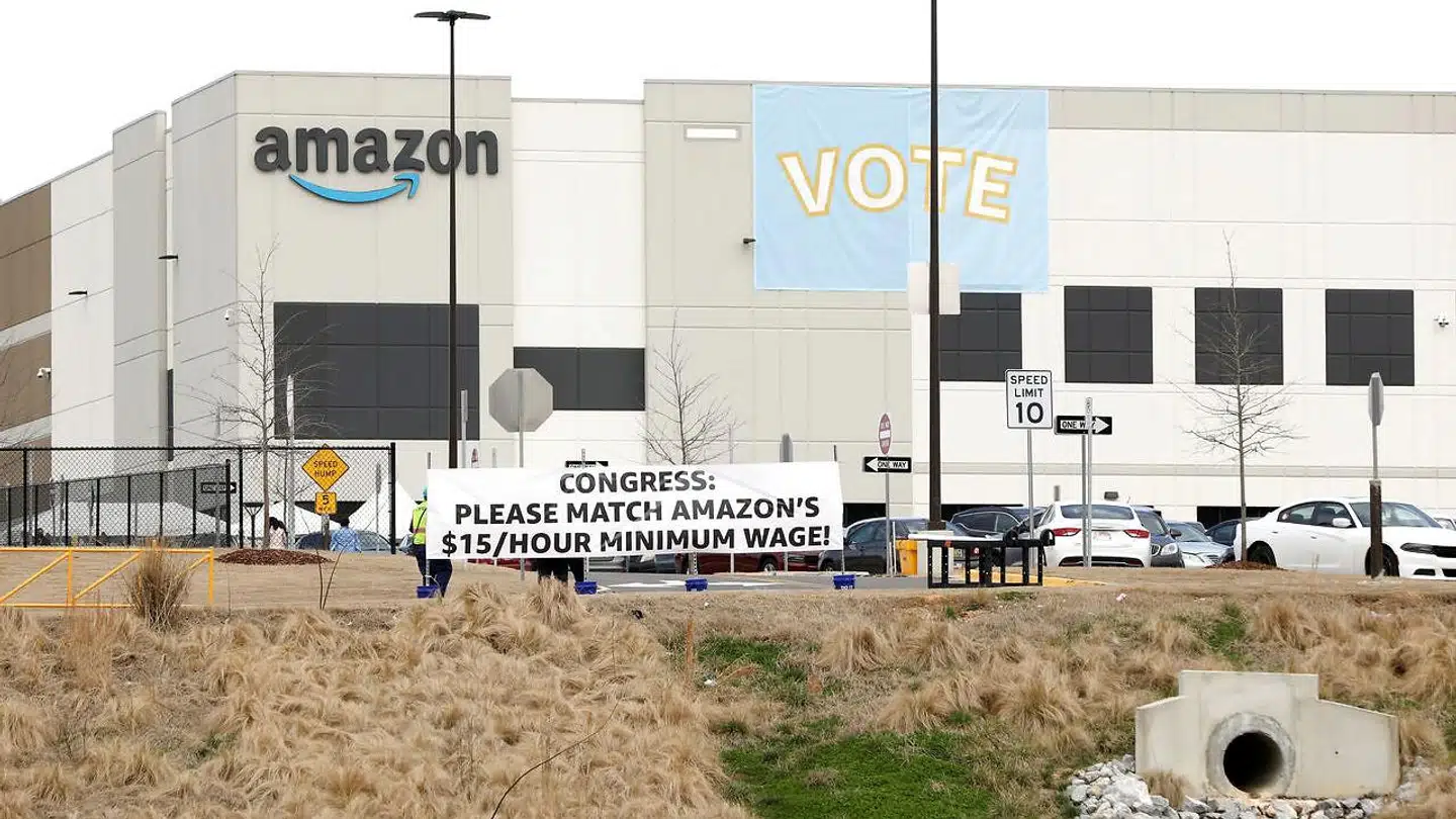 Bannere opsat uden for Amazons varehus i Bessemer i Alabama opfordrer politikerne til at vise deres støtte til de ansatte, som stemmer om, hvorvidt de kan komme med i en fagforening.