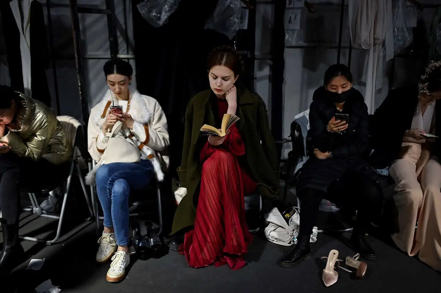En kinesisk model læser en bog, mens hun venter backstage til China Fashion Week i Beijing 25. marts 2021.