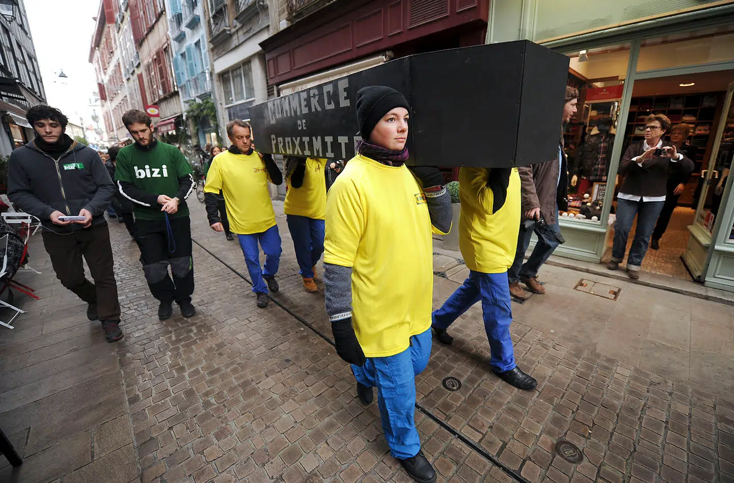 Medlemmer af antiglobaliseringsbevægelsen Bizi er klædt ud som IKEA-ansatte, mens de bærer en kiste i protest mod små lokale butikkers død i Bayonne i det sydvestlige Frankrig i 2013 i forbindelse med planer om at åbne et IKEA-møbelhus i området. Overvågningen af ansatte skal blandt andet også have været motiveret af denne type protestaktioner.
