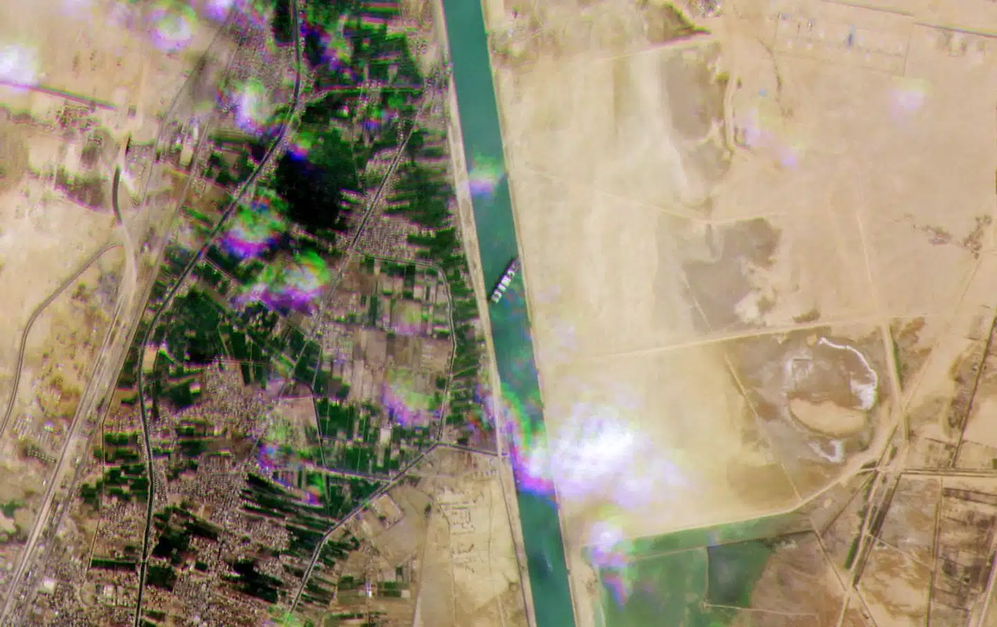 På dette satellitbillede fra Suez-kanalen er det tydeligt, hvordan det 400 meter lange containerskib har sat sig fast, så det ikke er muligt for anden trafik at passere.