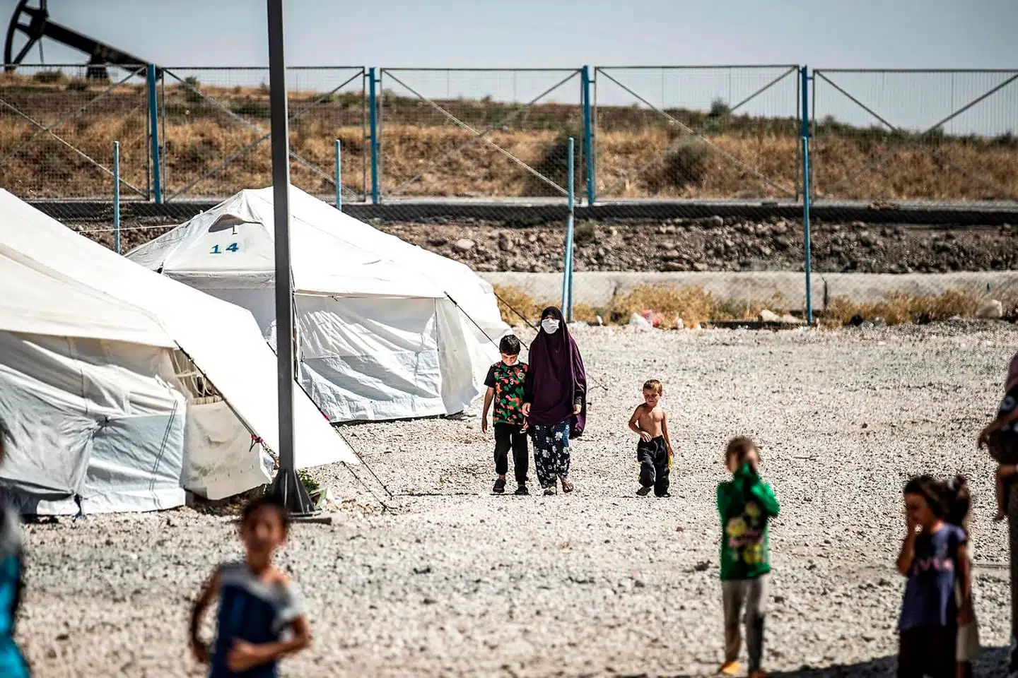 En kvinde går ved siden af et barn i al-Roj-lejren i det nordøstlige Syrien. Nationaliteten på personerne på billedet er ukendt.