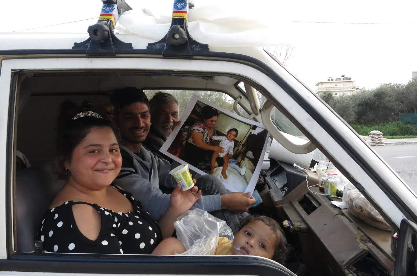 »En græsk familie fra landet sad i deres varevogn. Den unge kvinde i bilen skiftede sit barns ble oven på nogle tæpper, de havde til salg. Jeg tog et foto af hende, da hun sad med barnet, og senere gav jeg fotoet til familien og tog et foto igen. Den glæde, de viste, over, at man interesserede sig for deres liv, og den glæde, de viste, ved at få et foto af deres familie, den er fantastisk.«