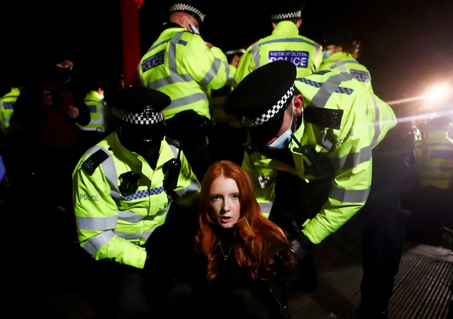 Police detain a woman as people gather at a memorial site in Clapham Common Bandstand, following the kidnap and murder of Sarah Everard, in London, Britain March 13, 2021. REUTERS/Hannah McKay TPX IMAGES OF THE DAY