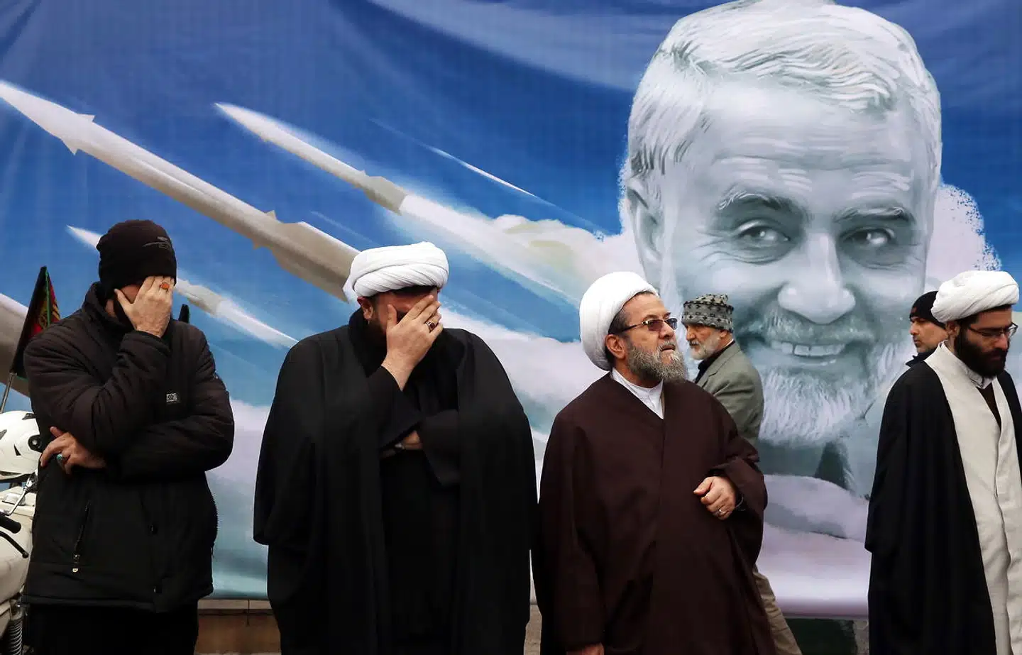 Iranske religiøse ledere står foran et billede af topgeneralen Qassem Soleimani, der sidste år blev dræbt i et amerikanske droneangreb.