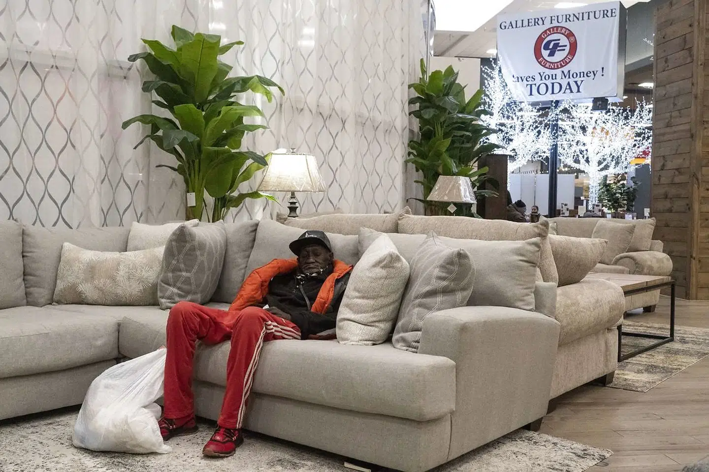 69-årige Doug Harper hviler sig på en sofa i møbelbutikken Gallery Furniture i Houston, mens stormen raser udenfor. Gallery Furniture har lavet deres butik om til en varmestue.