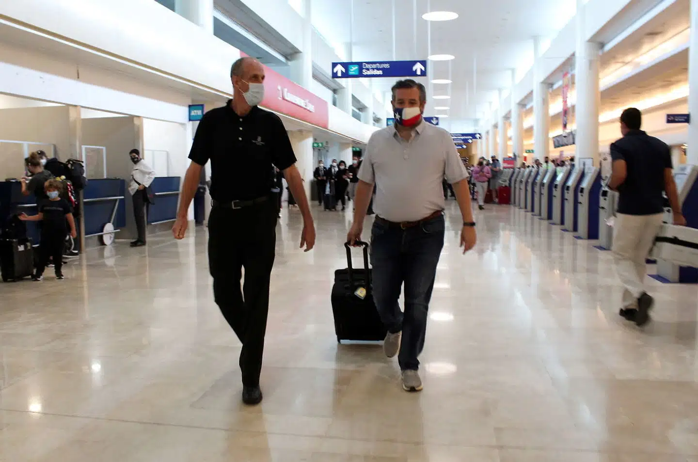 Ted Cruz (til højre) i Cancun International Airport torsdag før han gik ombord på et fly tilbage til USA efter en mediestorm og kun et døgn i Cancun.