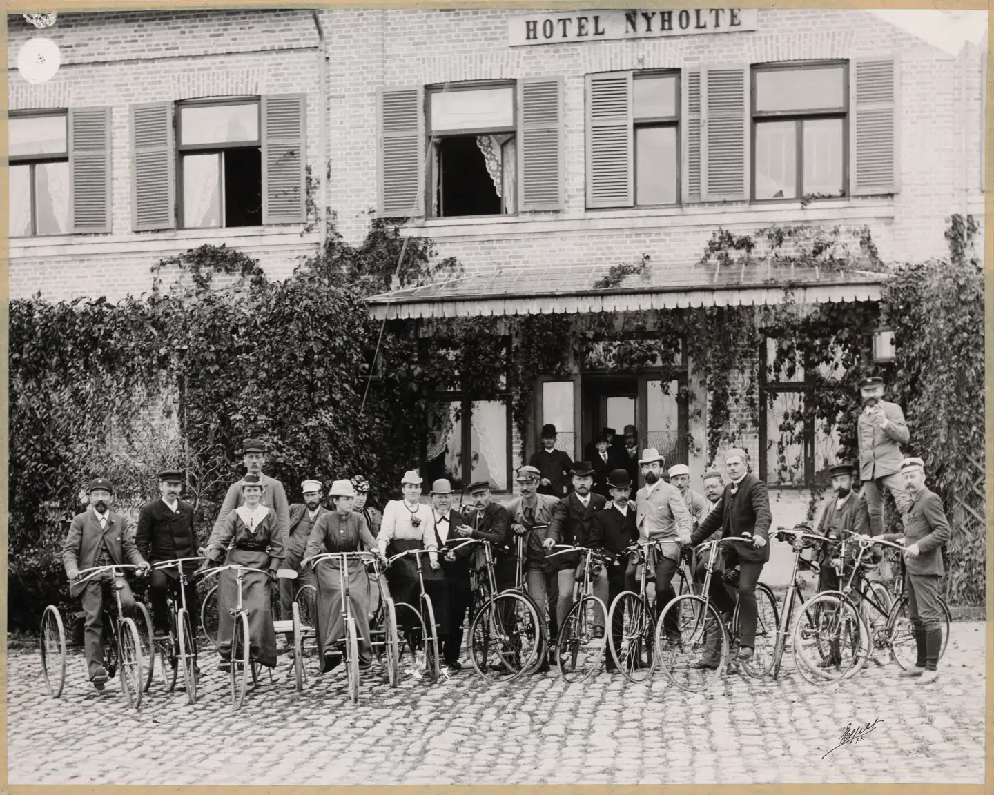 Snart kan man klikke ind på et digitalt danmarkskort og finde gamle fotos på deres præcise adresser. Her er cykelklubben på tur ved Hotel Nyholte – længe før lycra blev en del af outfittet på den tohjulede.