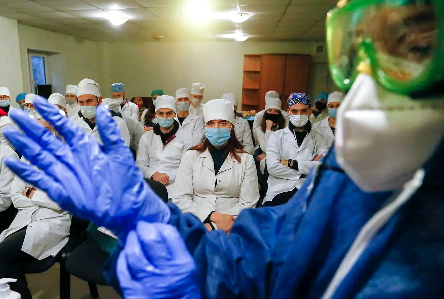 Ukraine har registreret over en million coronatilfælde, men endnu har landet ingen vaccinedoser – men det har nabolandet Rusland. Her ses en ukrainsk læge, der demonstrerer sikkerhedstiltag for medarbejdere på et coronaafsnit.