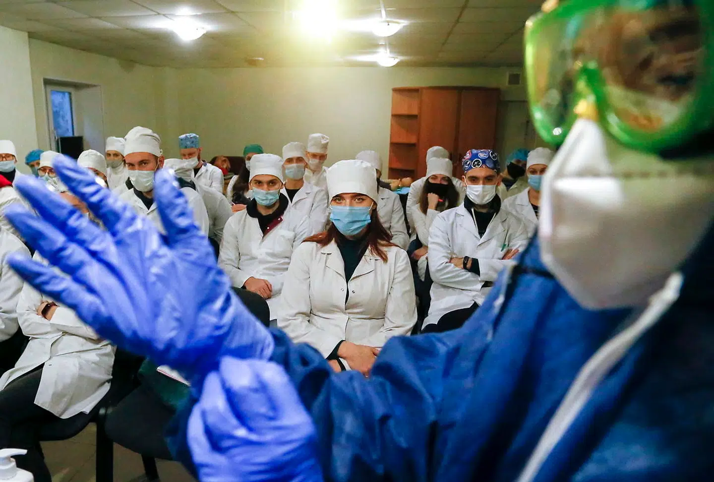 Ukraine har registreret over en million coronatilfælde, men endnu har landet ingen vaccinedoser – men det har nabolandet Rusland. Her ses en ukrainsk læge, der demonstrerer sikkerhedstiltag for medarbejdere på et coronaafsnit.