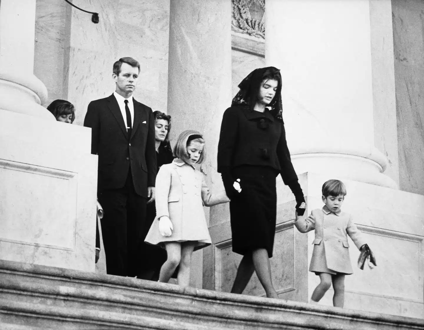 Jacqueline Onassis og børnene forlader John F. Kennedys begravelse i november 1963.