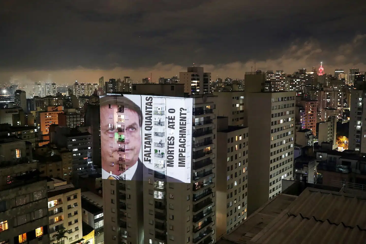 »Hvor mange skal dø, før der kommer en rigsretssag,« står der ved siden af den brasilianske præsidents, Jair Bolsonaros, portræt blæst op en boligblok i São Paulo.