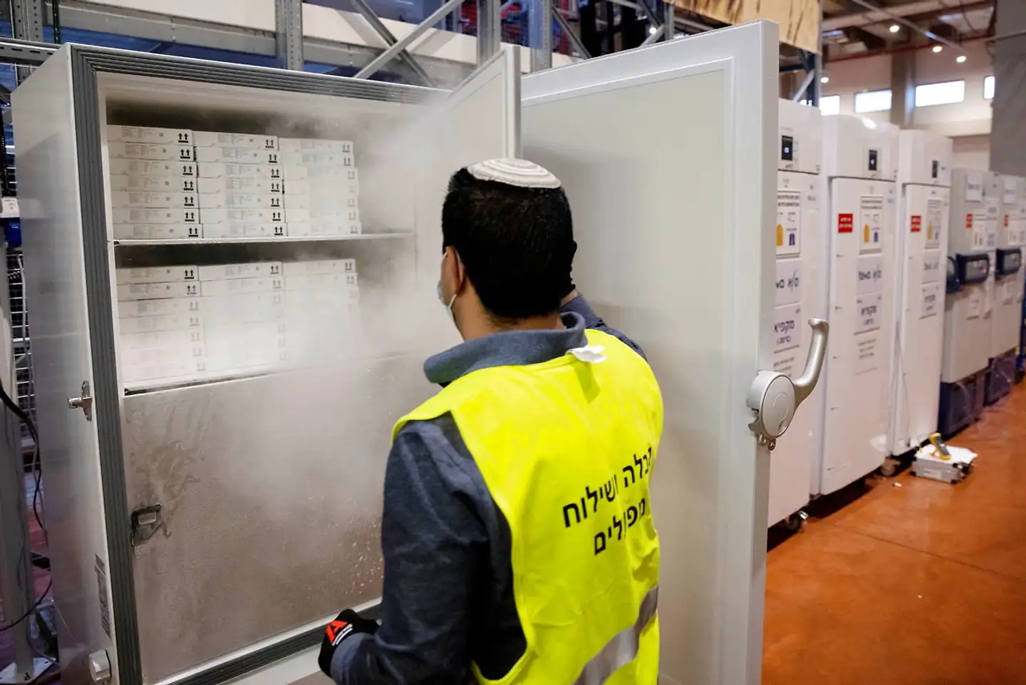 Teva råder over det største distributionsselskab for lægemidler i Israel og har eneret på opbevaring og distribution af coronavacciner i Israel. Her åbner en ansat en særlig fryser, der indeholder vacciner fra amerikanske Pfizer pakket i såkaldte »pizzabakker«.