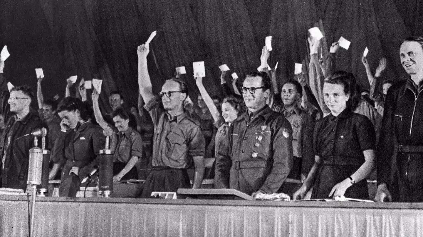 Erich Honecker (nummer tre fra højre), leder af kommunistpartiets ungdomsafdeling, smiler til sine kammerater ved et partimøde i 1946. Han blev i 1971 leder af kommunistpartiet og statsoverhoved fra 1976 til 1989. Ifølge Ines Geipels bog gjorde han op med sine gamle kommunistiske venner og fik en yngre generation af tidligere nazister ind i ledelsen.