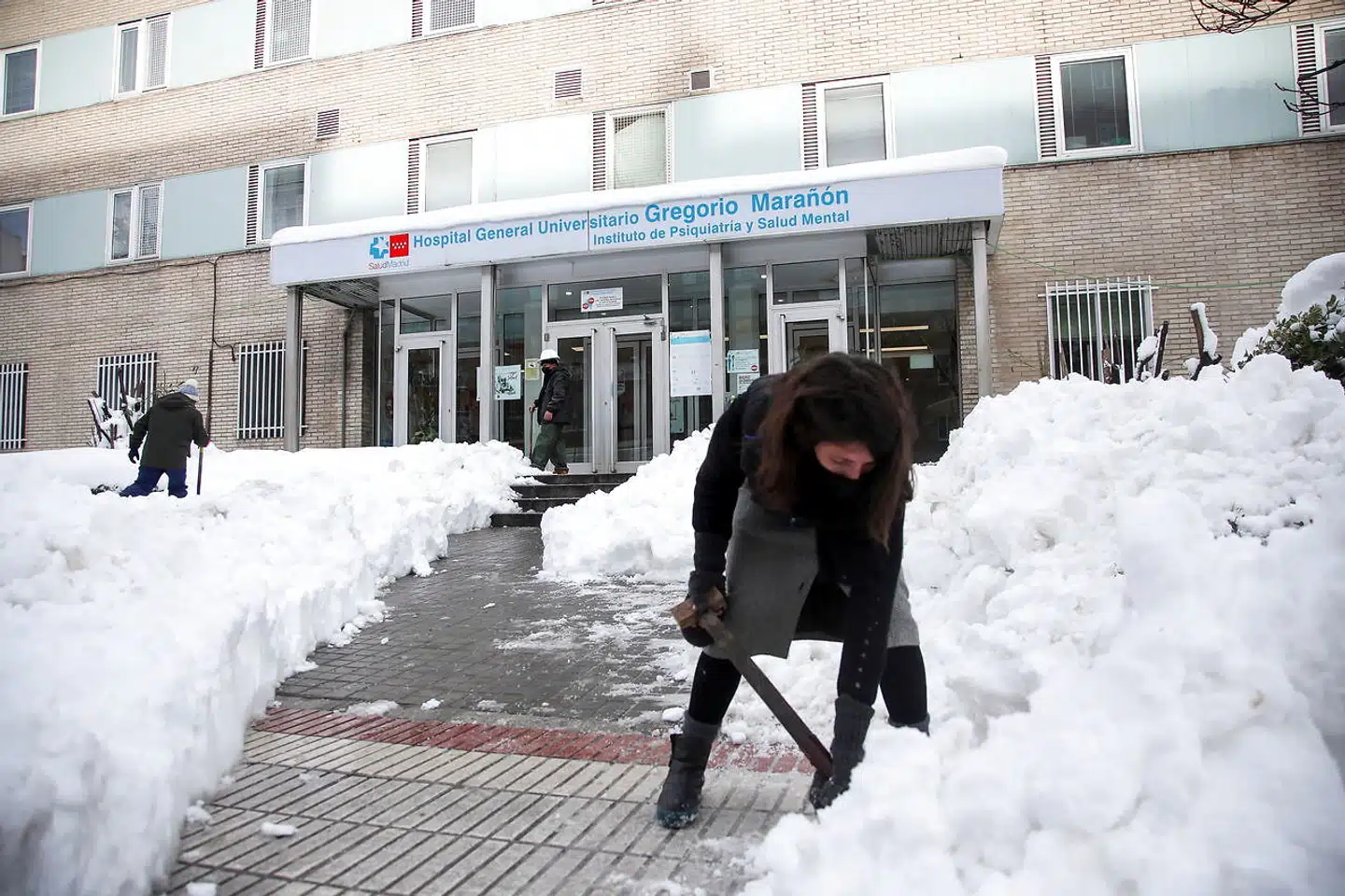 Frivillige skovler sne for at rydde en sikker sti ind til Gregorio Marañon-hospitalet i Madrid.