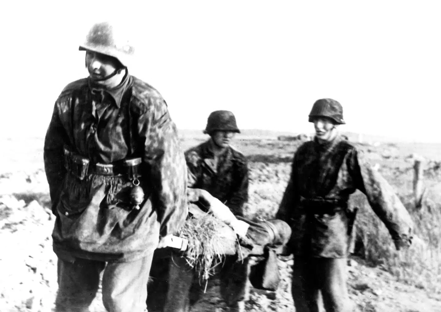 Tre Waffen-SS soldater fra Jylland bærer en såret kammerat væk fra fronten. Billedteksten er hentet fra bogen »Østfronten – danskere i krig« af Leif Davidsen og Karsten Lindhardt Bogen fik kritik for unøjagtige billedtekster. Scanpix.